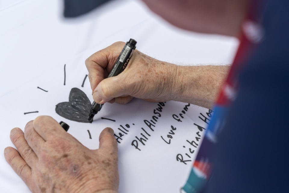 Participant signs on the quilt at the AIDS Quilt Memorial Ceremony, ahead of the Gay Games in Hong Kong, Saturday, Nov. 4, 2023. The first Gay Games in Asia are fostering hopes for wider LGBTQ+ inclusion in the regional financial hub, following recent court wins in favor of equality for same-sex couples and transgender people. (AP Photo/Chan Long Hei)