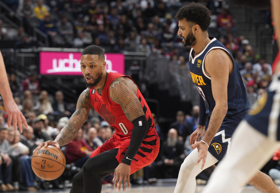 Portland Trail Blazers guard Damian Lillard, left, drives past Denver Nuggets guard Jamal Murray in the first half of an NBA basketball game Tuesday, Jan. 17, 2023, in Denver. (AP Photo/David Zalubowski)