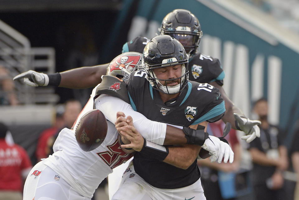 Tampa Bay Buccaneers linebacker Sam Acho, left, forces a fumble as he sacks Jacksonville Jaguars quarterback Gardner Minshew (15) during the second half of an NFL football game, Sunday, Dec. 1, 2019, in Jacksonville, Fla. (AP Photo/Phelan M. Ebenhack)