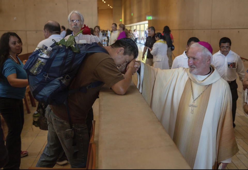 FILE - Auxiliary Bishop David O'Connell, right, from the San Gabriel Pastoral Region, is revered by an unidentified pilgrim, left, after a special "Mass in Recognition of All Immigrants'' at the Los Angeles Cathedral of Our Lady of Angels in Los Angeles Sunday, June 24, 2018. O'Connell, a Roman Catholic bishop in Southern California was shot and killed Saturday, Feb. 18, 2023, just blocks from a church, a slaying that's stunned the Los Angeles religious community, authorities said. Detectives are investigating the death of Bishop O’Connell as a homicide, according to the Los Angeles County Sheriff's Department. (AP Photo/Damian Dovarganes, File)