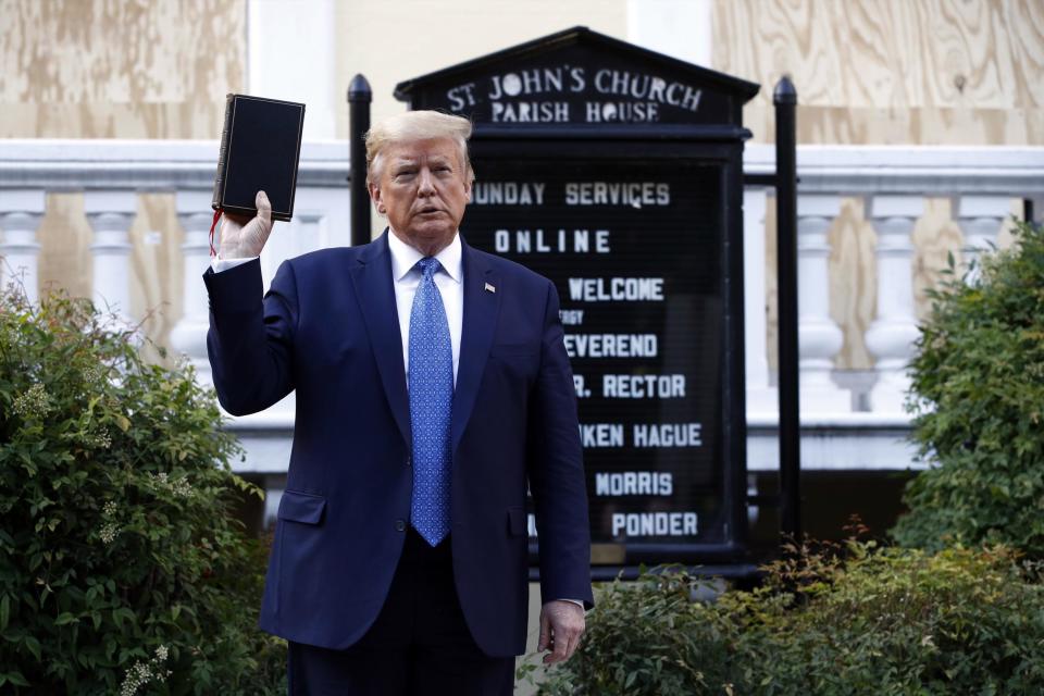 President Donald Trump holds a Bible as he visits St John's Church (AP)