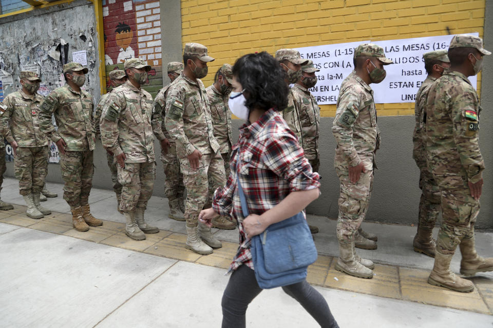 Military police stand in line outside a polling station for their turn to vote during general elections in La Paz, Bolivia, Sunday, Oct. 18, 2020. (AP Photo/Martin Mejia)