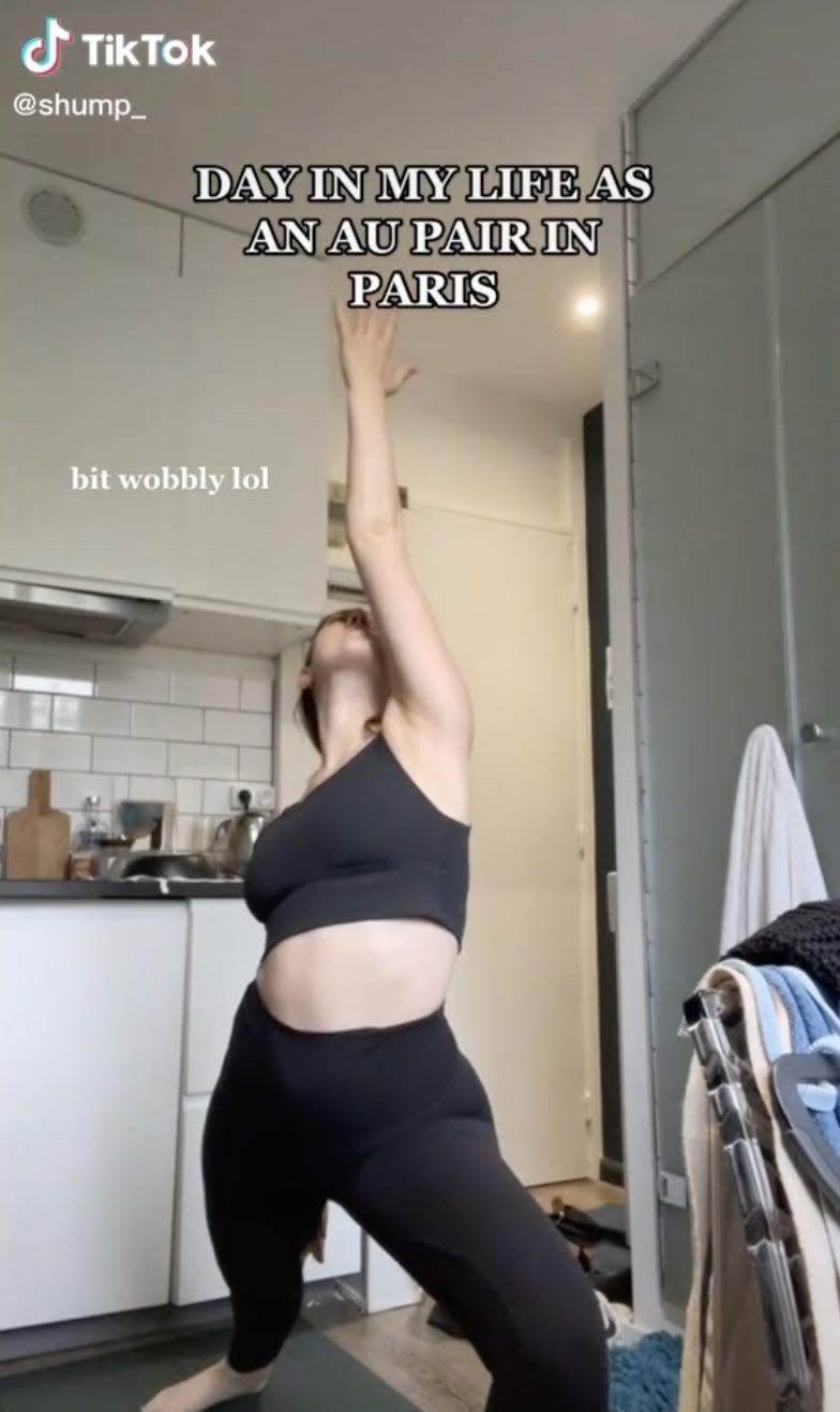 Screenshot of the TikToker doing yoga in her apartment.