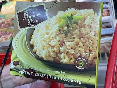 hand holding box of trader joe's brown rice