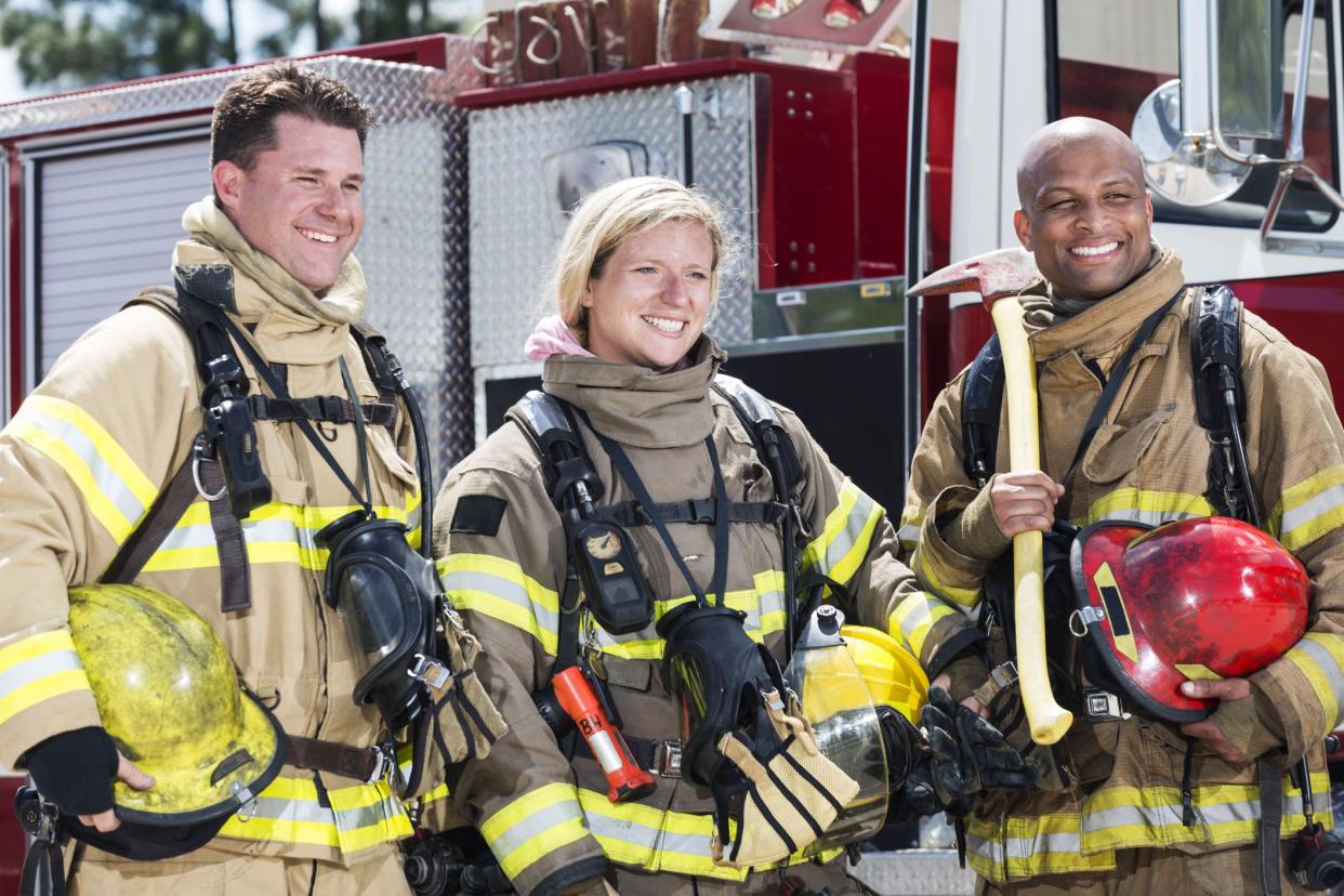 three firefighters standing outside truck in uniform