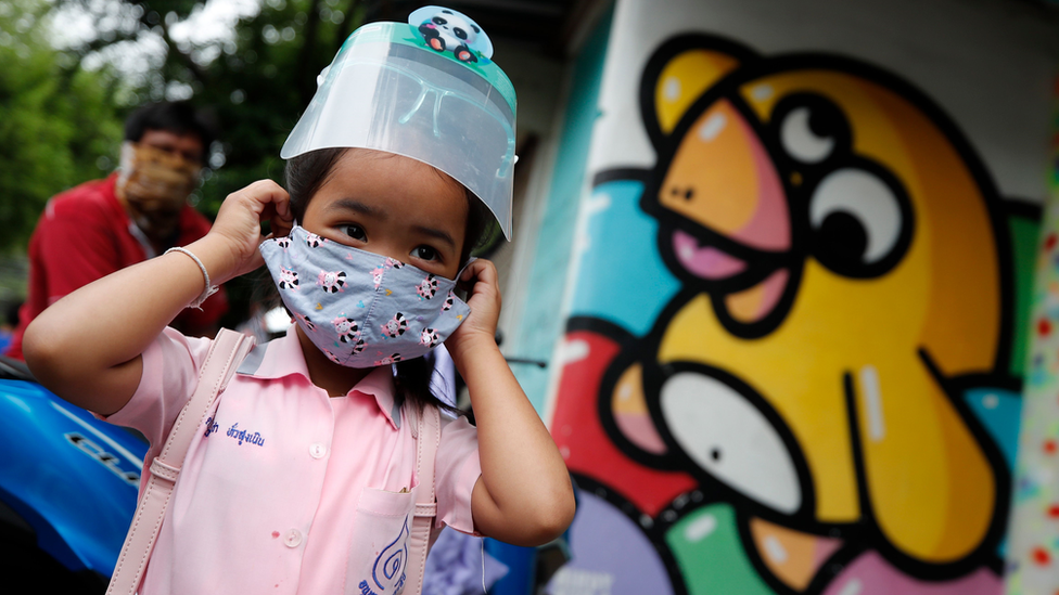 Niña yendo a la escuela en Tailandia con mascarilla.