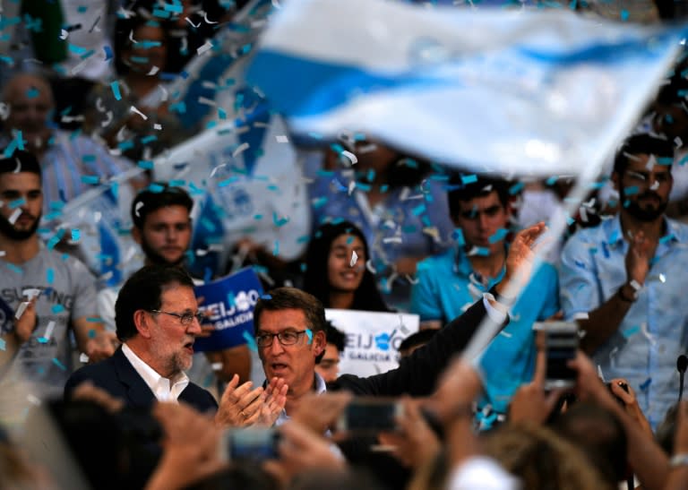 Popular Party candidate for upcoming regional elections in Galicia, Alberto Nunez Feijoo and Spain's acting Prime Minister Mariano Rajoy wave to supporters