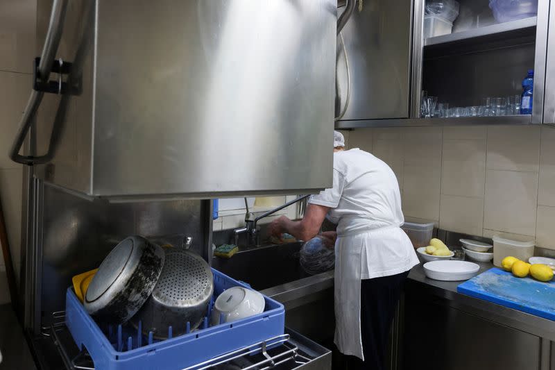 Migrants at work in the kitchen of a Milan restaurant