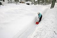 Ethel O'Leary is dwarfed by snowbanks as she helps clear the sidewalk in front of her house after her nephew went over it with the snowblower in Duluth, Minnesota December 5, 2013. People from Texas to New York were bundling up December 5 against winter weather that closed schools and businesses, blanketed roads and power lines with ice and threatened to disrupt travel across a wide swath of the United States. REUTERS/Bob King/Duluth News Tribune