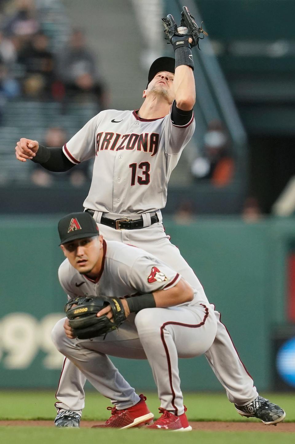 Diamondbacks shortstop Nick Ahmed catches a pop up behind second baseman Josh Rojas.