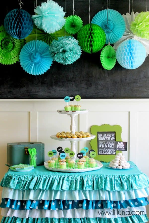 a dessert table with aqua and green details, a great baby shower idea, including ruffles, cupcakes and more