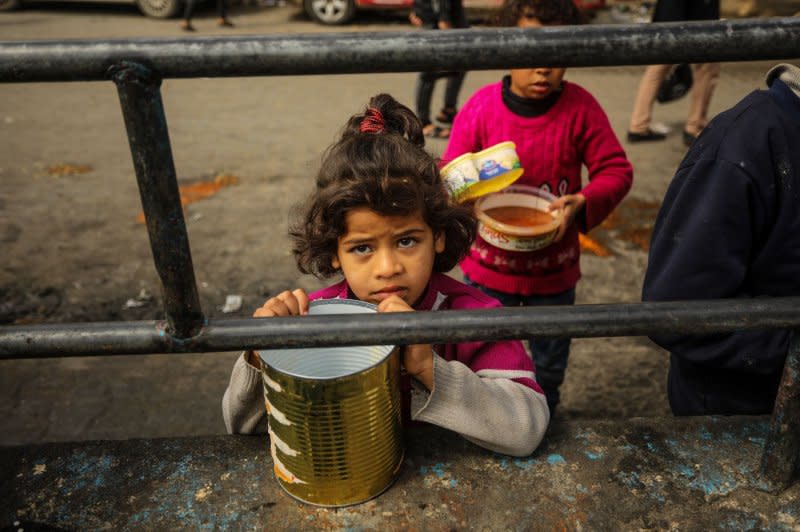 A girl waits for food amid supply shortages in Rafah in the southern Gaza Strip on March 6. Photo by Ismael Mohamad/UPI