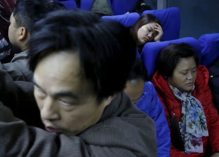 Migrant worker Lai Yongmei, 47, sleeps on a bus on her way into Beijing, China, November 16, 2015. REUTERS/Kim Kyung-Hoon