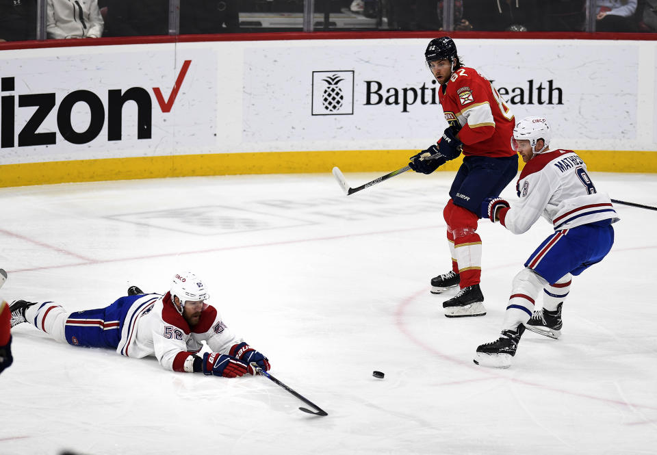 Montreal Canadiens defenseman David Savard (58) dives in front of the puck as teammate Mike Matheson and Florida Panthers center Kevin Stenlund watch during the first period of an NHL hockey game, Saturday, Dec. 30, 2023, in Sunrise, Fla. (AP Photo/Michael Laughlin)