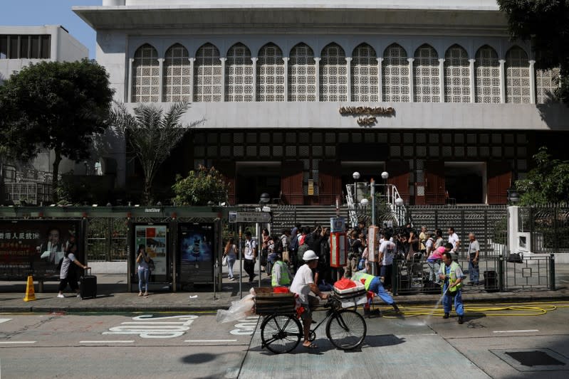 Cleaners wash the road outside Kowloon Masjid and Islamic Centre as people go about their day in Hong Kong’s tourism district Tsim Sha Tsui