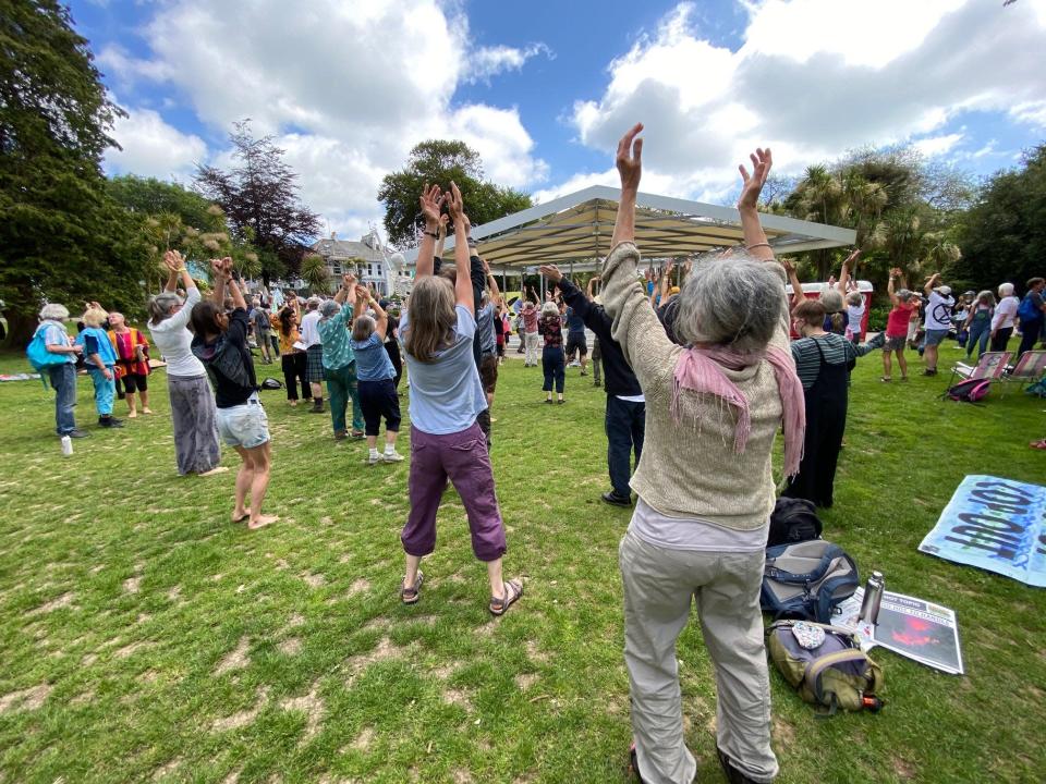 Activists gather in Kimberley Park, in Falmouth, England, on June 12, 2021, as they rehearse for a protest march involving a dance routine.