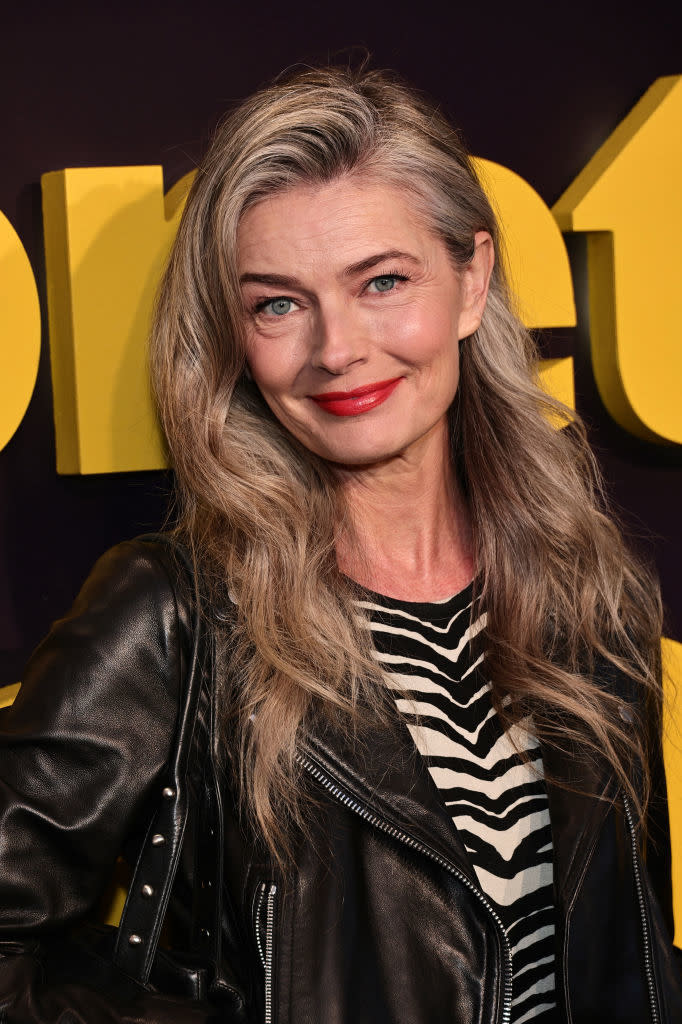 Paulina Porizkova wearing a leather jacket over a striped top at an event
