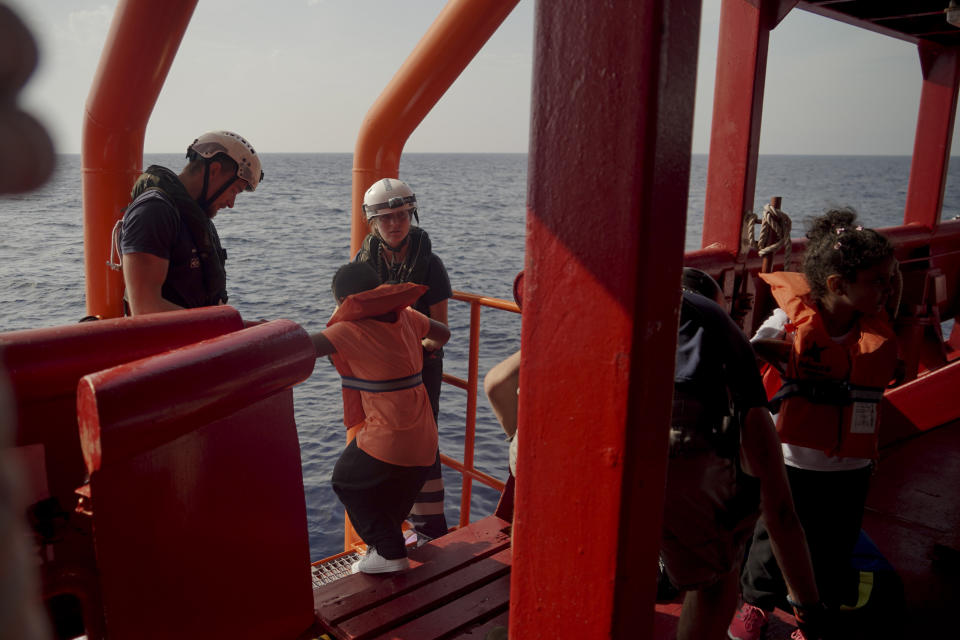 SOS Mediterranee crew help children disembark from the Ocean Viking into Maltese rescue ships in the Mediterranean Sea, Friday, Sept. 20, 2019. Malta has agreed to take in 35 migrants fleeing Libya who were rescued by the humanitarian ship a day earlier. (AP Photo/Renata Brito)