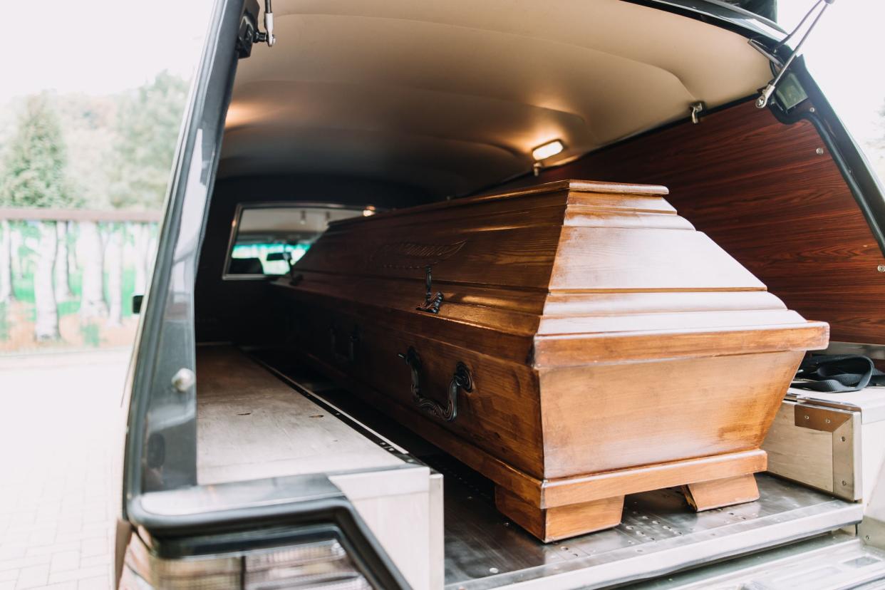 photo of a coffin car at a funeral heading to the graveyard