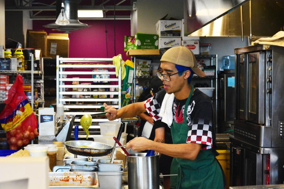 Pasta La Fata employee Elkin Cardenas dollops basil pesto into some linguine Thursday at the business' Rogers Street location. All food is served to-go, but tables are available for customers to sit and enjoy their food.