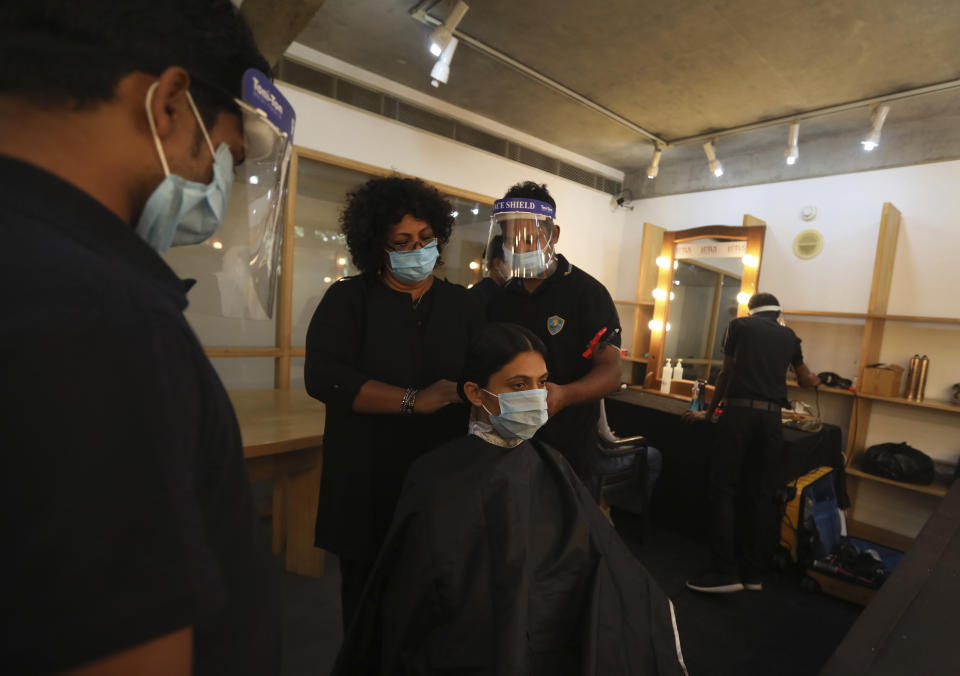 A model gets her hair done for a shoot for the Lotus make-up India Fashion week digital show at the Fashion Design Council of India (FDCI) office in New Delhi, India, Friday, Oct. 2, 2020. India’s first digital fashion week is being held from Oct. 14-18, live streaming the spring-summer collections by more than 40 fashion designers under the banner of Lotus Make-up India Fashion Week. Not to miss the October deadline, the FDCI converted parts of its office building into a studio in a bustling industrial area of Delhi. Models, film crew, photographers, designers and FDCI staff could step in after duly checked and negative coronavirus test results. Face masks were mandatory for everyone, except briefly, for the models on stage. (AP Photo/Manish Swarup)