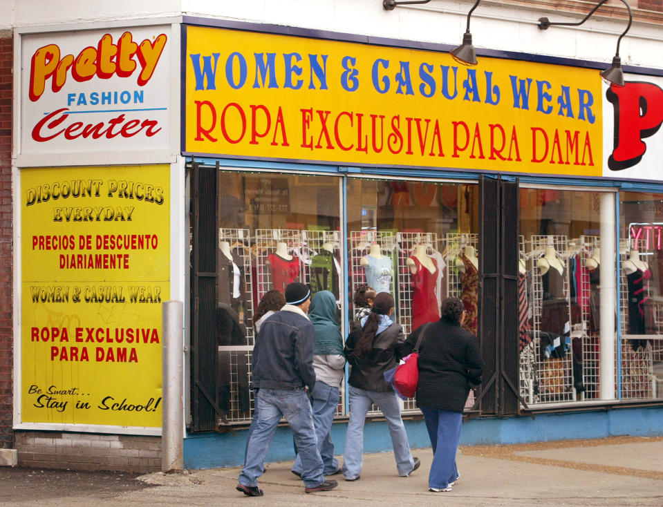 CHICAGO - MARCH 9: Pedestrians pass a clothing store with signage in both English and Spanish March 9, 2004 in Chicago's largely Hispanic Little Village neighborhood. The U.S. Census Bureau reports the nation's Hispanic population has grown to become the largest minority. (Photo by Tim Boyle/Getty Images)