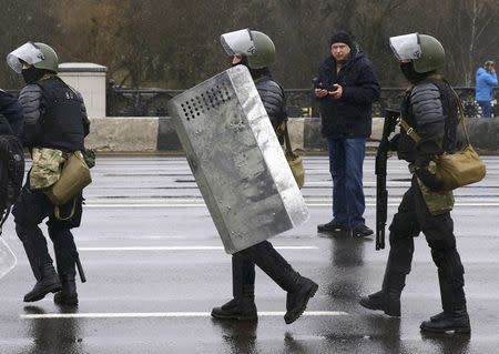 Law enforcement officers walk during a gathering, denouncing the new tax on those not in full-time employment and marking the 99th anniversary of the proclamation of the Belarussian People's Republic, in Minsk, Belarus, March 25, 2017. REUTERS/Vasily Fedosenko