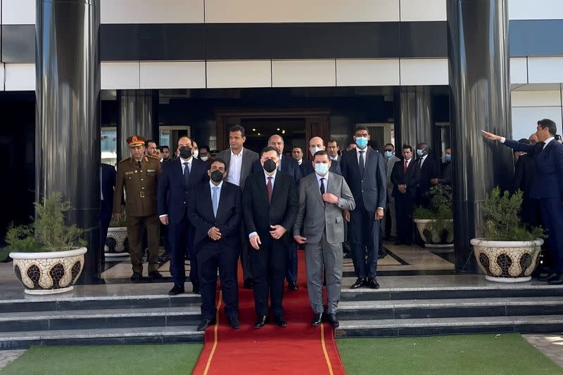 Libya's Prime Minister Abdulhamid Dbeibeh, Libya's internationally recognized former Prime Minister Fayez al-Sarraj, and Mohammed al-Menfi, Head of the Presidency Council, pose for a photo after the handover ceremony in Tripoli