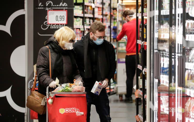 FILE PHOTO: People wearing protective face masks are seen in a supermarket in Posillipo