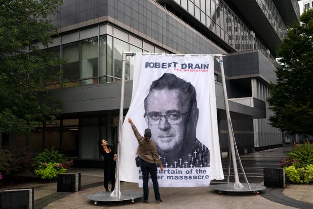 An image of federal bankruptcy judge Robert Drain is installed by protesters in front of Purdue Pharma’s headquarters (Mark Lennihan/AP)