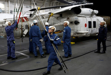 A female maintenance specialist works on a SH-60K Sea Hawk helicopter in the hangar deck of Japanese helicopter carrier Kaga in Indian Ocean, Indonesia, September 23, 2018. REUTERS/Kim Kyung-Hoon