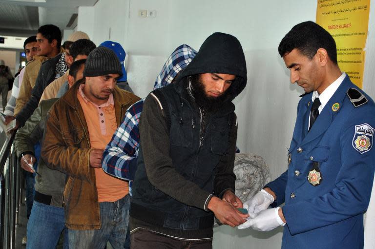 Egyptians, who were formerly residing in Libya, have their documents checked by Tunisian customs at Djerba airport on the Tunisian-Libyan border, before their departure for Cairo, on February 23, 2015