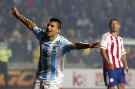 Argentina's Sergio Aguero celebrates after scoring a goal as Paraguay's Ivan Piris looks on during their Copa America 2015 semi-final soccer match at Estadio Municipal Alcaldesa Ester Roa Rebolledo in Concepcion, Chile, June 30, 2015. REUTERS/Andres Stapff