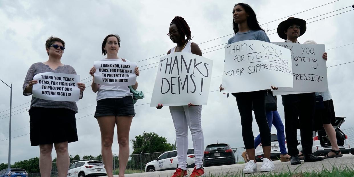 Supporters hold signs for Texas legislative Democrats staging a walkout over voting legislation