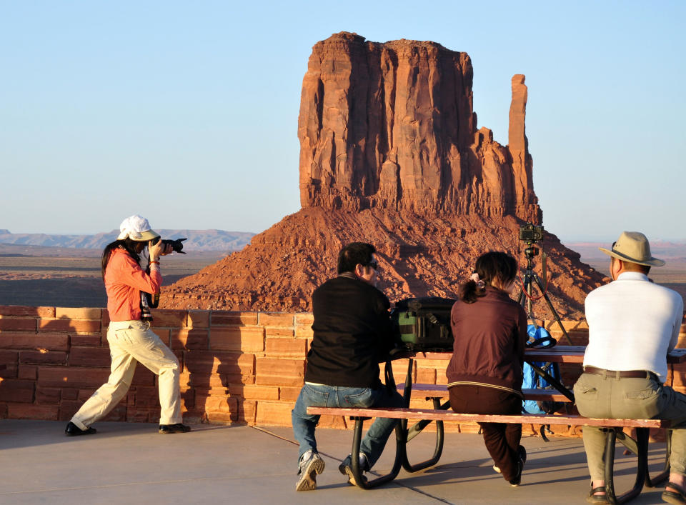 This undated image provided by the Navajo Tourism Department shows visitors at Monument Valley Navajo Tribal Park in northeastern Arizona. An economic impact study and yearlong survey show spending by tourists on the Navajo Nation has increased by nearly one-third since 2002. (AP Photo/Navajo Tourism Department, Roberta John)