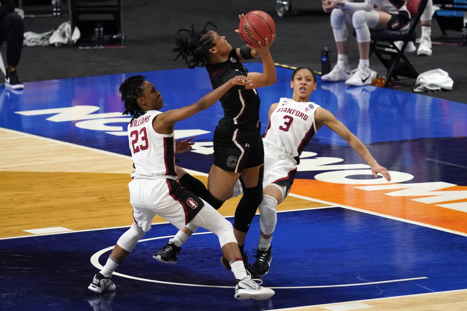 South Carolina guard Zia Cooke, center, drives to the basket between Stanford guard Kiana Williams (23) and guard Anna Wilson (3) during the first half of a women's Final Four NCAA college basketball tournament semifinal game Friday, April 2, 2021, at the Alamodome in San Antonio. (AP Photo/Eric Gay)