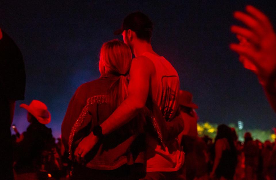 A couple embraces as they watch Miranda Lambert perform on the Mane Stage during Stagecoach country music festival in Indio, Calif., Saturday, April 27, 2024.