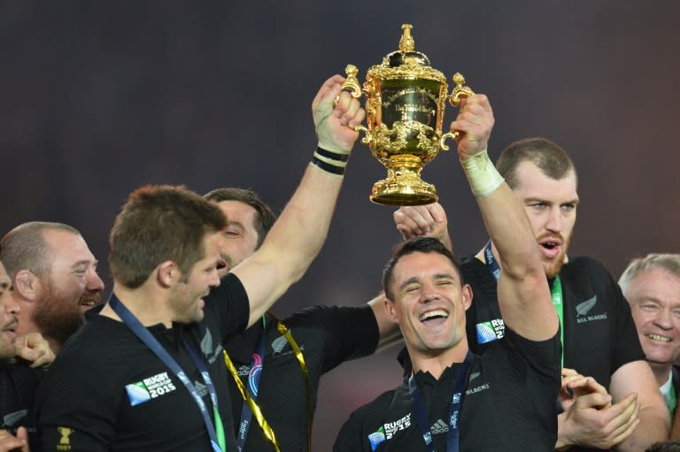 New Zealand fly-half Dan Carter (R) and captain Richie McCaw (L) hold the Webb Ellis Cup after winning the 2015 Rugby World Cup final against Australia at Twickenham, south-west London, on October 31, 2015