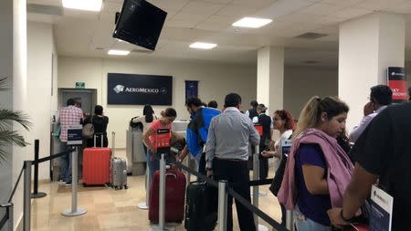 People stand in line at the Aeromexico desk at the Durango Airport after an Aeromexico-operated Embraer passenger jet crashed right after takeoff in Mexico's state of Durango, July 31, 2018, in this picture obtained from social media. Contacto Hoy/via REUTERS