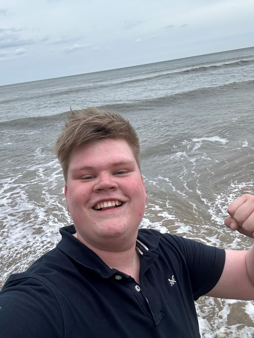 Teenager stands on the beach in front of the sea