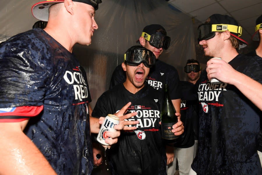 The Cleveland Guardians, including Steven Kwan, center, celebrate after their 10-inning win over the Minnesota Twins in a baseball game to clinch a playoff berth Thursday, Sept. 19, 2024, in Cleveland. (AP Photo/Nick Cammett)