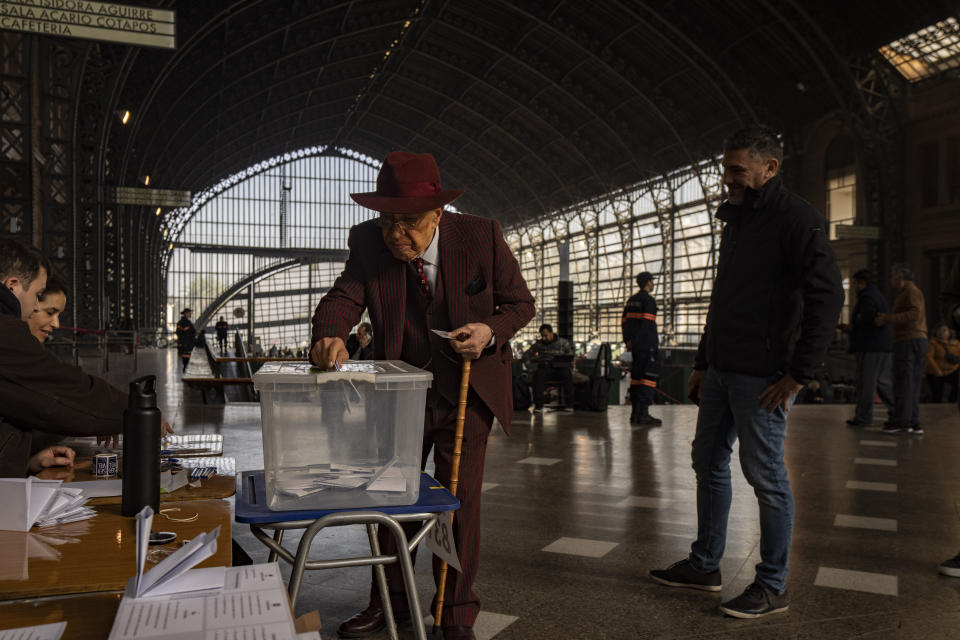 An elderly man votes during an election to choose members of a Constitutional Council who will draft a new constitution proposal, at the old Mapocho train station, now a cultural center, in Santiago, Chile, Sunday, May 7, 2023. A first attempt to replace the current charter bequeathed by the military 42 years ago was rejected by voters during a referendum in 2022. (AP Photo/Esteban Felix)
