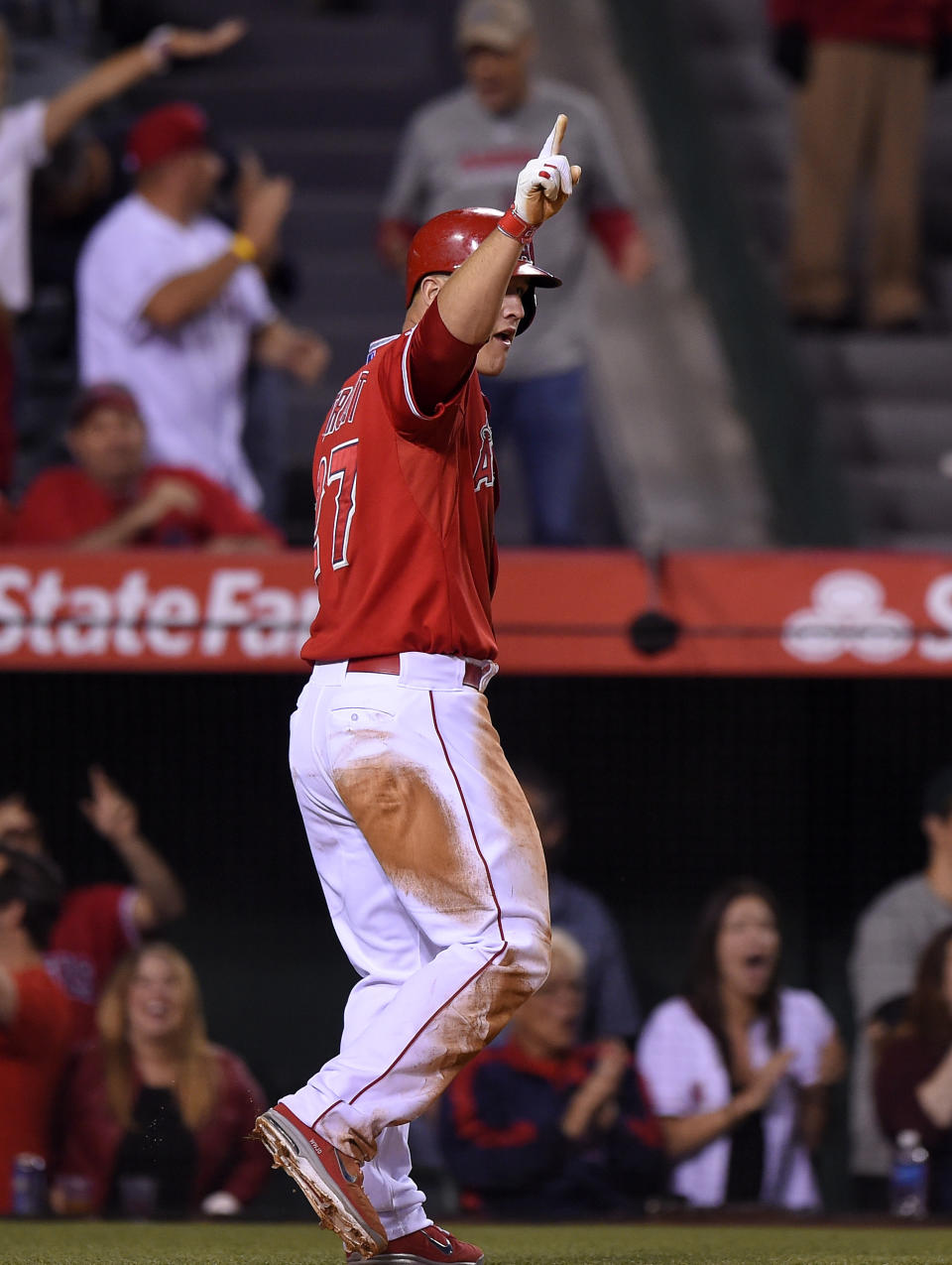 Los Angeles Angels' Mike Trout point to first base after scoring on a hit by Howie Kendrick during the ninth inning of a baseball game against the Oakland Athletics, Wednesday, April 16, 2014, in Anaheim, Calif. (AP Photo/Mark J. Terrill)