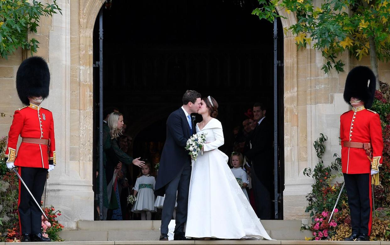Princess Eugenie of York and Jack Brooksbank kiss as they leave after their wedding at St George's Chapel in Windsor Castle on October 12, 2018 in Windsor, England.