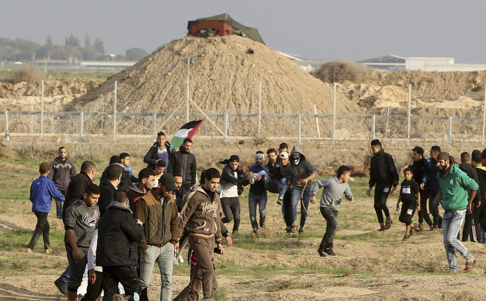 Protesters evacuate a wounded youth from near the fence of the Gaza Strip border with Israel during a protest east of Gaza City, Friday, Nov. 16, 2018. (AP Photo/Adel Hana)