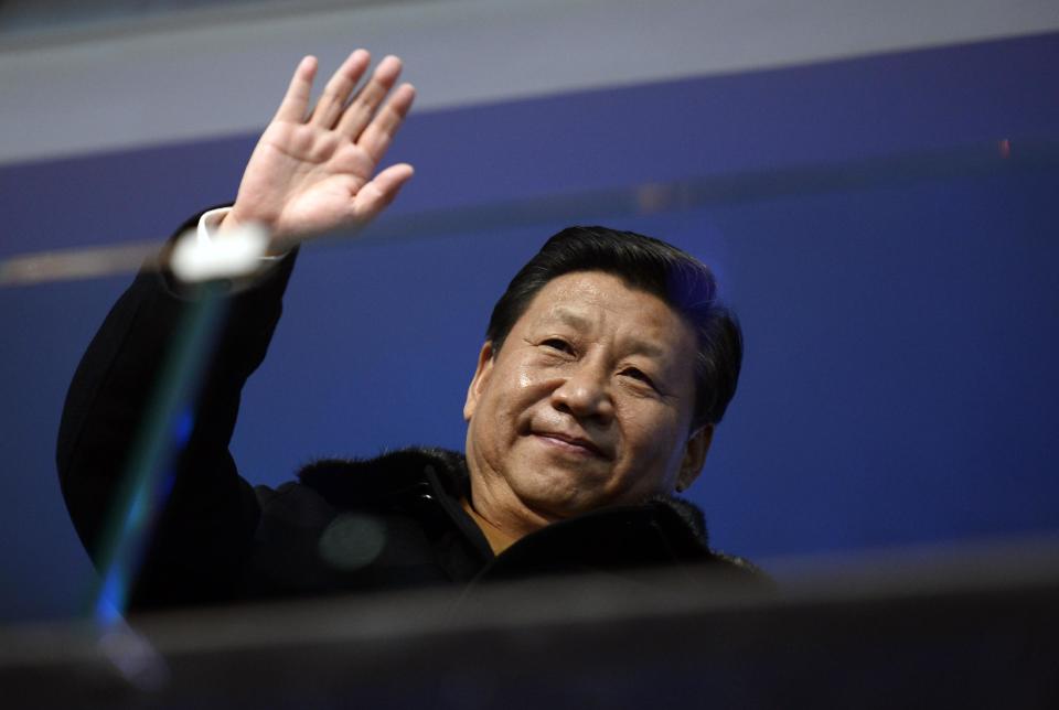 China's President Xi Jinping waves from the presidential tribune during the opening ceremony of the 2014 Winter Olympics in Sochi, Russia, Friday, Feb. 7, 2014. (AP Photo/Lionel Bonaventure, Pool)