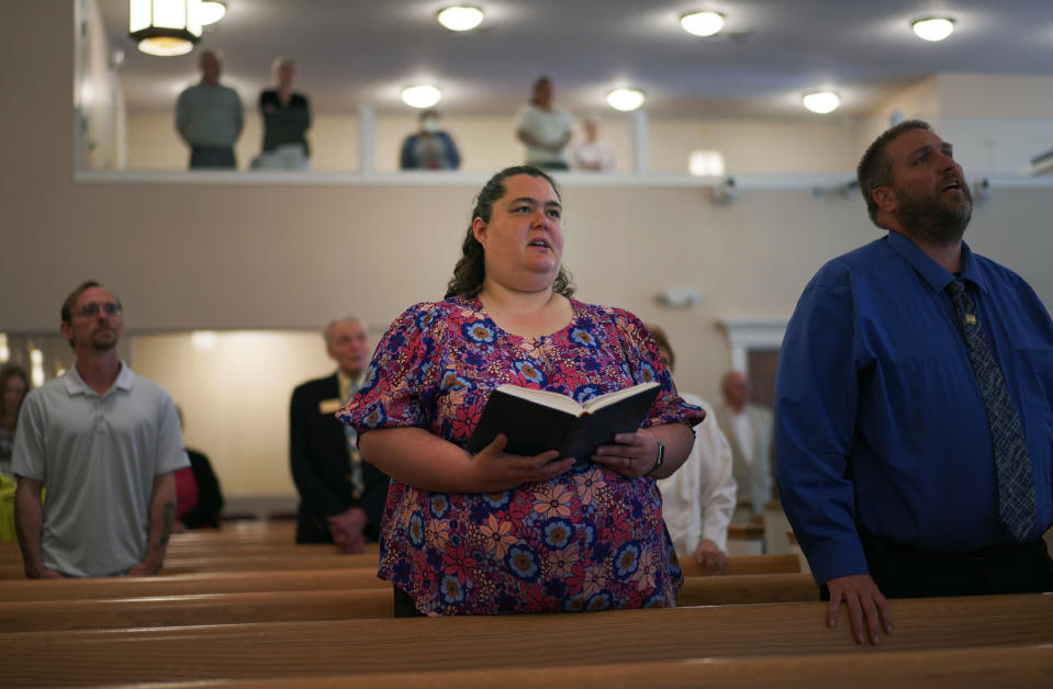 Fern Creek Baptist Church members Tiffany Keranen, center, and her husband, Kevin, right, sing with the congregation, Sunday, May 21, 2023, in Louisville, Ky. (AP Photo/Jessie Wardarski)