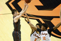 Oklahoma guard Alondes Williams (15) shoots while under pressure from Oklahoma State guard Cade Cunningham (2) and forward Matthew-Alexander Moncrieffe (12) during an NCAA college basketball game Monday, March 1, 2021, in Stillwater, Okla. (AP Photo/Brody Schmidt)