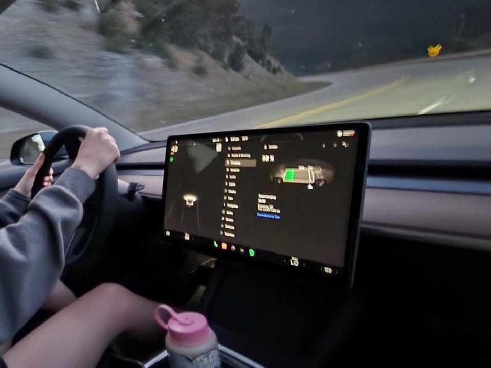 A Tesla driving after sunset.