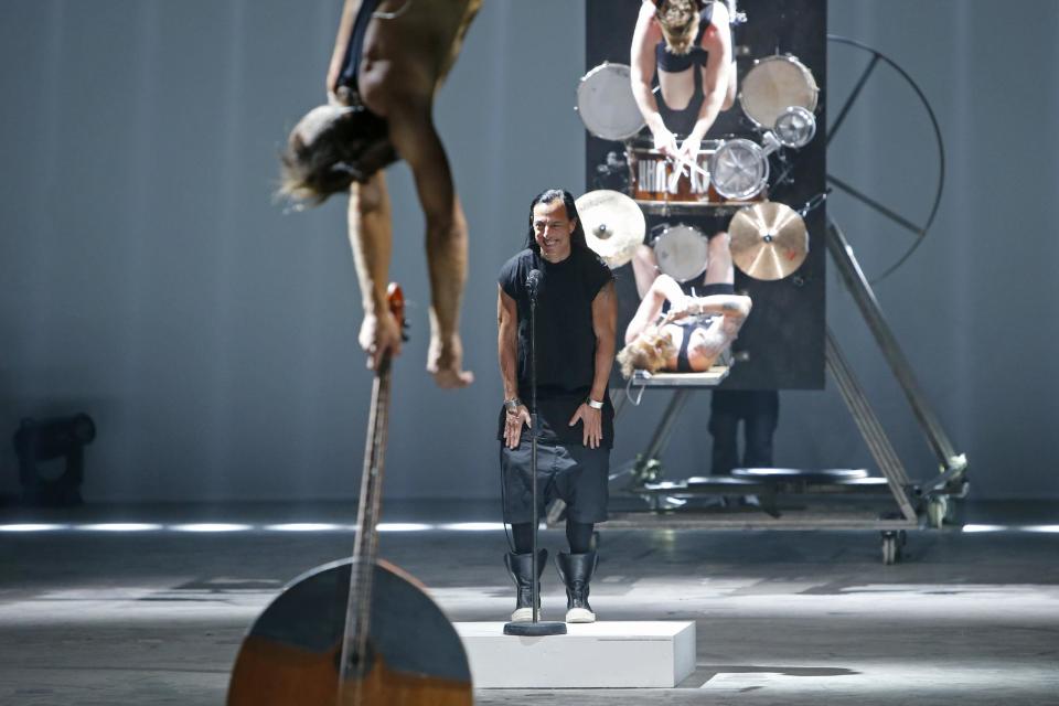 Fashion designer Rick Owens, rear centre, acknowledges applause following the presentation of his men's fashion Spring-Summer 2014 collection, Thursday, June 27, 2013 in Paris, as Estonian metal/punk band Winny Puhh perform live, suspended by their feet. (AP Photo/Francois Mori)